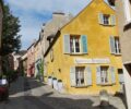 Marly le Roi street with a yellow house and green window shutters
