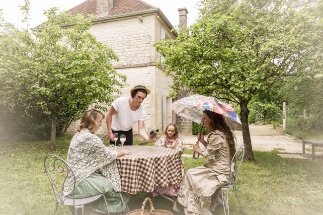 Ladies dressed in traditional clothing being served drinks