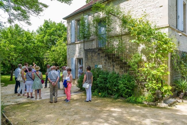 A group of people in front of A beautiful cottage filled with plants