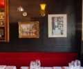 Tables laid out by a wall decorated with lights and paintings